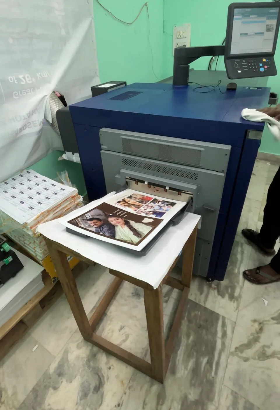 A digital printing machine producing a personalised photo layout.
